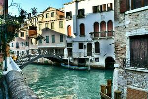 a canal in venice with a bridge and buildings photo
