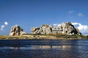 Seaside Serenity Charming Cottage Amidst Rocky Coastline photo