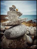 Serene Breton Beach Cairn of Pebbles with Ocean Background photo