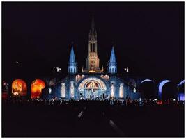 iluminado basílica de lourdes a noche foto