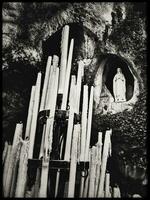 piadoso velas a lourdes gruta con María estatua en monocromo foto