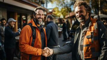 retrato de dos sonriente hombres en naranja chaquetas sacudida manos en el calle. construcción trabajadores, ingenieros y arquitectos foto