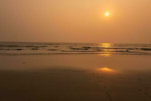 foam of sea or ocean waves against the backdrop of the setting sun photo