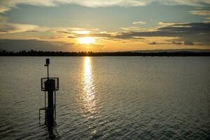 Sunset over the reservoir The sun's rays hit the surface of the water. photo