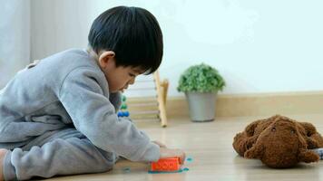 Asian boy having fun playing toy on the floor video