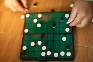 White and black stones are placed on a wooden board for playing Go. photo