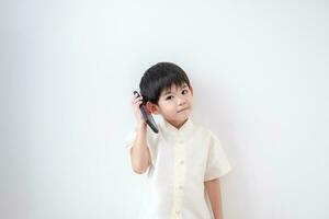 Asian boy Wear traditional Thai clothing Talk on the phone on a white background photo