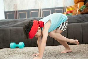 Asian boy in tank top doing exercise And there was a sweat towel on his head. photo