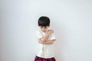 Asian boy Wearing traditional Thai clothing, standing with arms crossed. on a white background photo