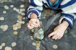 Asian boy happily counting coins to save money photo