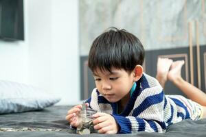 Asian boy happily counting coins to save money photo