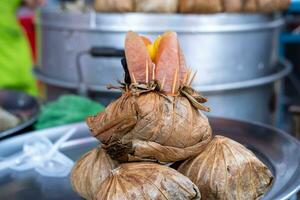 zongzi o licenciado en Letras jang, producto muestras metido en inoxidable acero platos para clientes a ver. foto