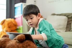 Asian boy studying online and doing activities on laptop photo