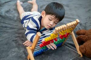 Asian boy playing with toys on the bed photo