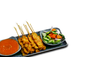 Pork Satay on plate. Grilled pork served with peanut dipping sauce,toasted bread and sweet sour sauce decorated with cucumber,onion and chili. One of the best Thai street food. png