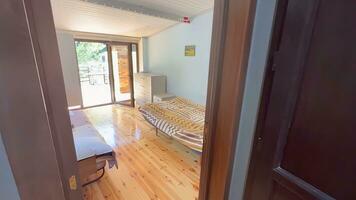 Interior of a bedroom with hardwood floor and wooden bed photo