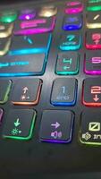 A gaming keyboard that has colorful LED lights, with the main color of the keyboard being black. It has a shape that is very suitable for the hand when typing or playing games. video