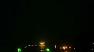 Airplane landing at night. The runway is illuminated with landing lights video