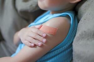 A boy hurts his arm, holding his bandaged arm. photo