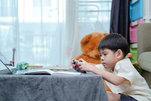 asiático chico estudiando en línea en móvil teléfono foto