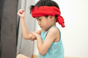 Asian boy in tank top doing exercise And there was a sweat towel on his head. photo