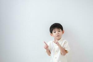 Asian boy Wearing traditional Thai clothing, standing with index finger upwards. on a white background photo