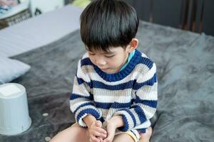 Asian boy happily counting coins to save money photo