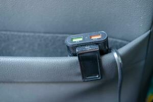 Power bank with charging cable plugged in Store in the back seat pocket of your car. photo