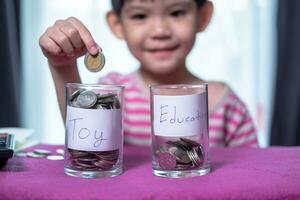 Male Asian boy holding a silver coin Choose to save money between toys or studying. photo