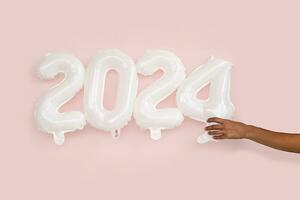 2024 New year concepts. Ladies hand holdind Inflatable balloon numbers. photo