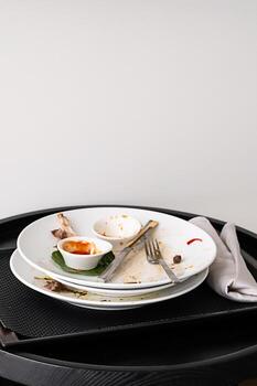 Stack of messy plates left on table after diner. photo