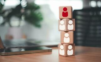 One wooden block has leadership and stands out with red manager icon placed on table as human resource management concept for leadership and teamwork. photo