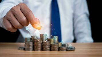 Businessman puts money on pile of coins. Ideas for investing and growing a business, maximizing profits from business, ideas for setting savings goals and setting goals for fixed deposits with banks. photo