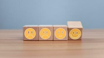 Mental health and emotional state concept, Smile face  and sad face on wooden block cube for positive mindset selection concept. photo