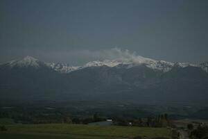 clouds over the mountains and farms photo