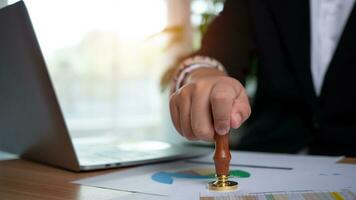 Businessman hand using wooden stamping to document approve and reject document or project, Signing a business contract approval of contract documents confirmation, approval stamp, copy space. photo