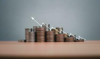 Coins are lined up on a wooden floor along with index charts, arrows and candlesticks. Represents financial, economic, business growth concepts. Financial success concept. Abstract finance background. photo