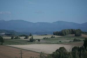 clouds over the mountains and farms photo
