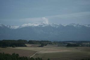 clouds over the mountains and farms photo