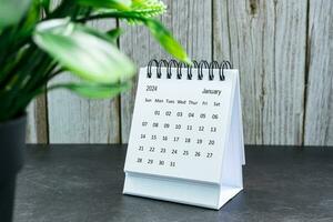 White January 2024 calendar on wooden desk. 2024 New Year Concept photo