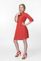 rubia hembra vestido en verano rojo polca punto vestir en pie en lleno longitud en blanco antecedentes foto