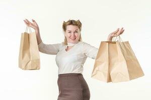 Waist up photo of happy smiling blonde woman holding shopping paper disposable bags with purchases