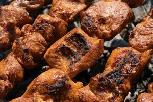 Grilled pork shish kebab cooking on skewers on charcoal grill photo