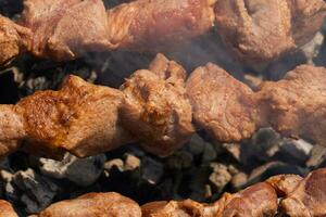 Close-up view grilled tasty pork shish kebab cooking on skewers charcoal grill photo