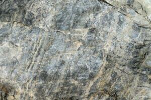 Rough stone surface grey color. Detailed nature background or pattern texture photo