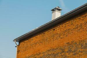 Close up chimney on roof and sky, brick wall of house photo