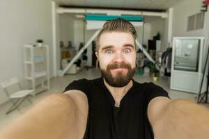 Happy bearded man taking selfie or having video call at home. Technology, people and lifestyle concept photo