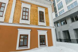 Street with houses cold weather. Snow day in winter. Building in city center covered with snow. photo