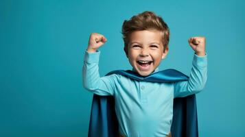 A young boy wearing a superhero costume stands in a triumphant pose photo