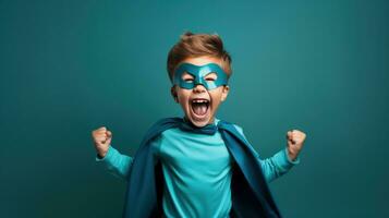 A young boy wearing a superhero costume stands in a triumphant pose photo